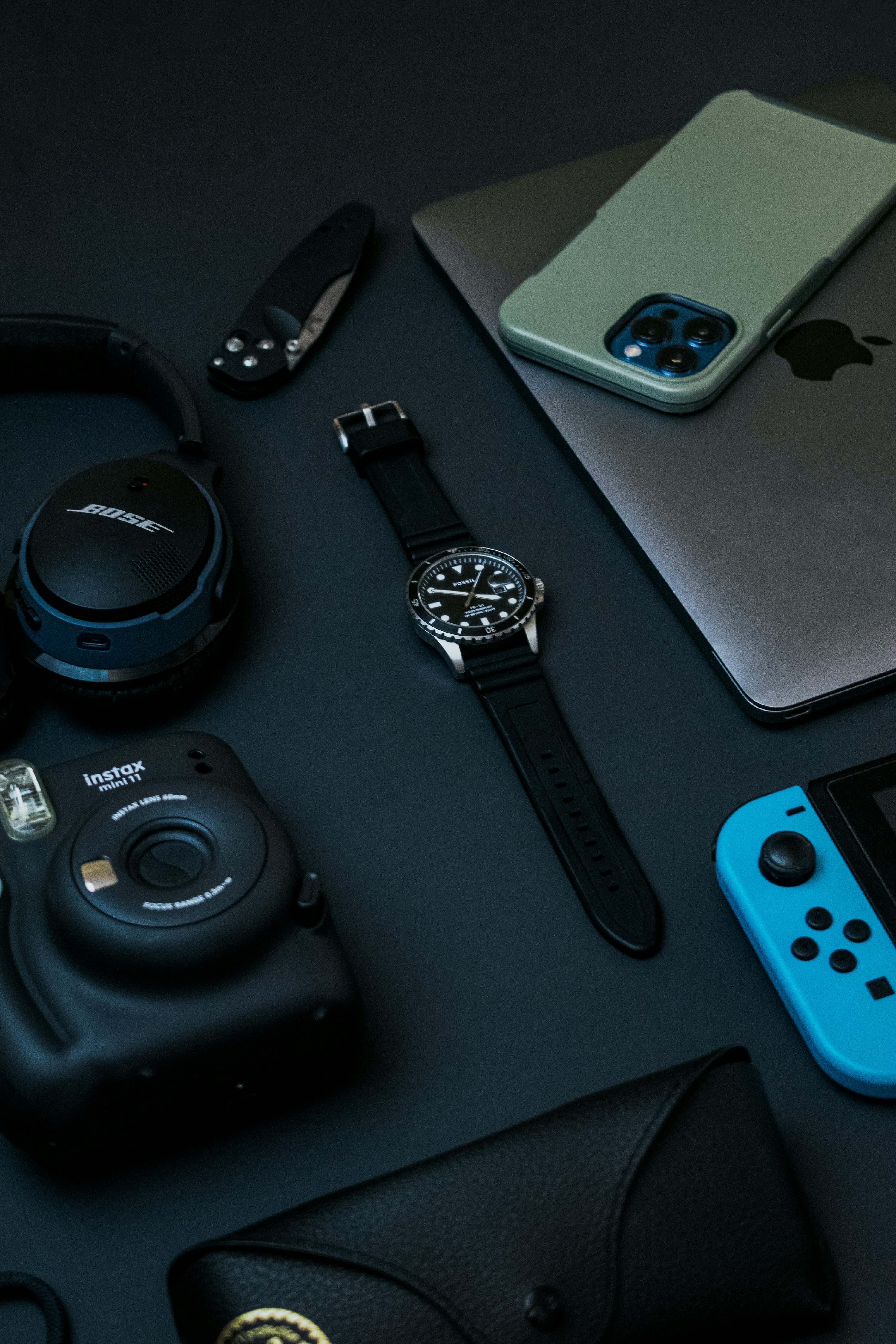 Orologio analogico rotondo nero e argento accanto all'iPhone 6 in argento e all'orologio rotondo nero e argento